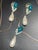 This mid-century vintage demi-parure set features striking earrings of pear-cut focal rhinestones in a deep teal or...