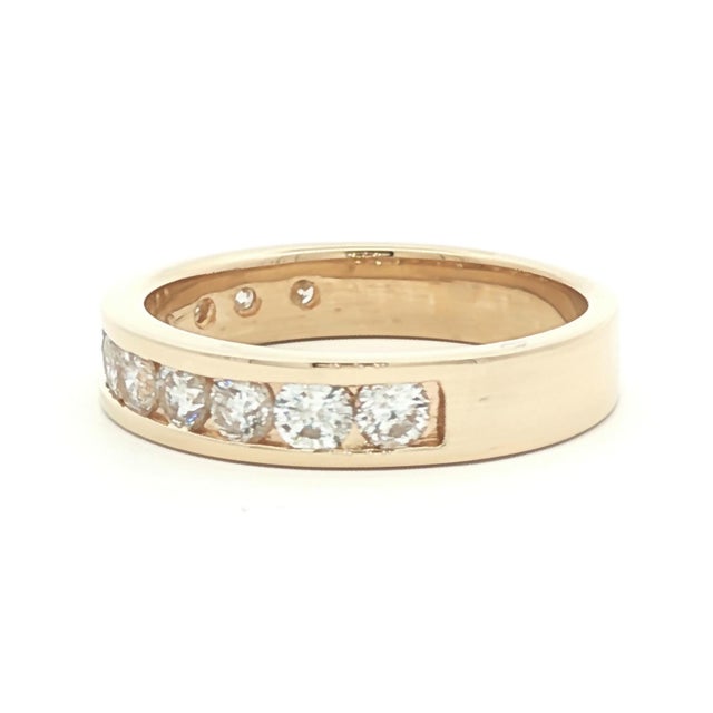 A vintage 14k gold wedding ring featuring a row of channel-set brilliant-cut white diamonds. The diamonds are slightly...