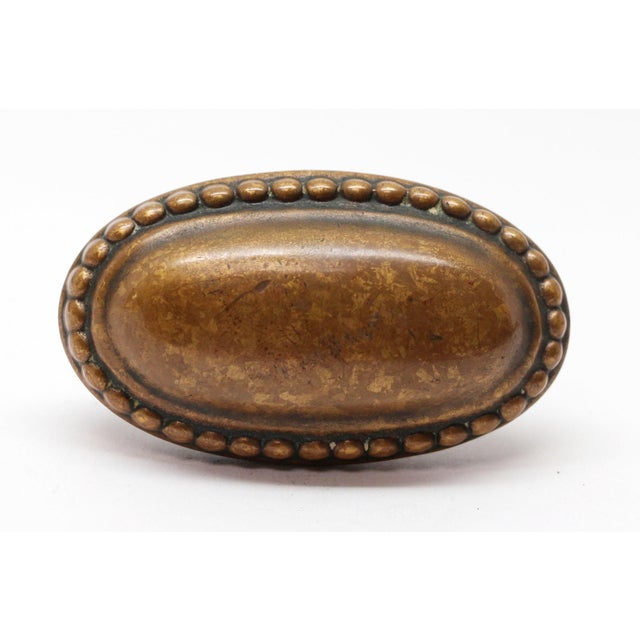 Beaded trim knob with a plain center made of bronze in an antique finish. The manufacturer and date of creation is...