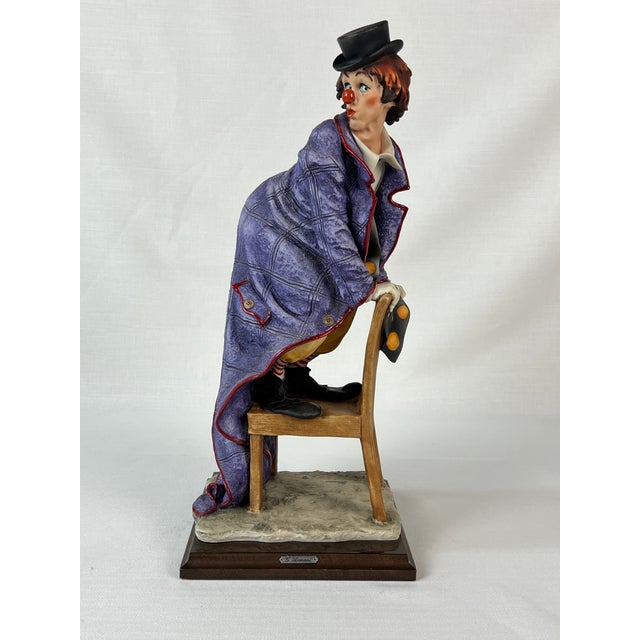 An exquisite life-like porcelain figurine created and signed by renowned artist Giuseppe Armani called “Clown on Chair”...