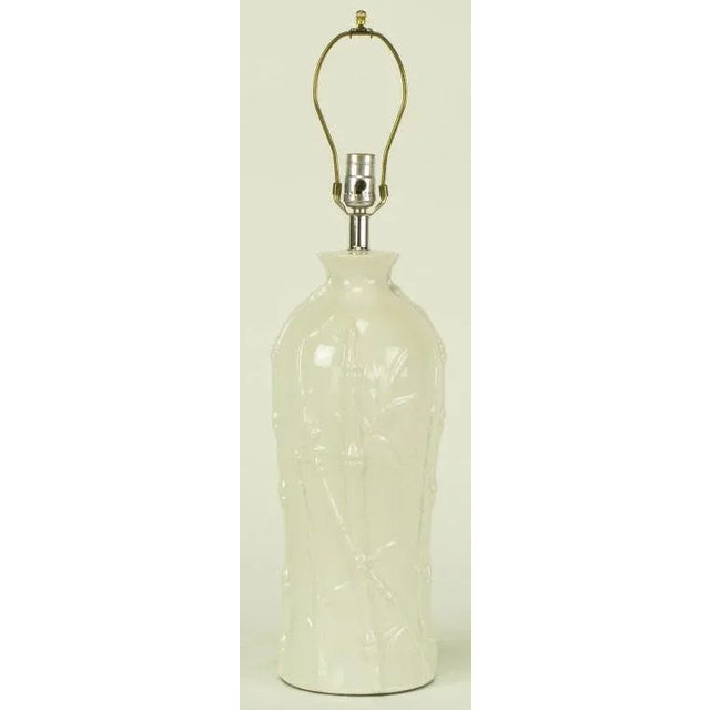 white glazed ceramic table lamp in bottle form with bamboo stalk and foliate relief. Sold sans shade.