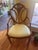 This elegant vintage armchair features a classic shield-back design adorned with intricate hand-painted floral motifs in...