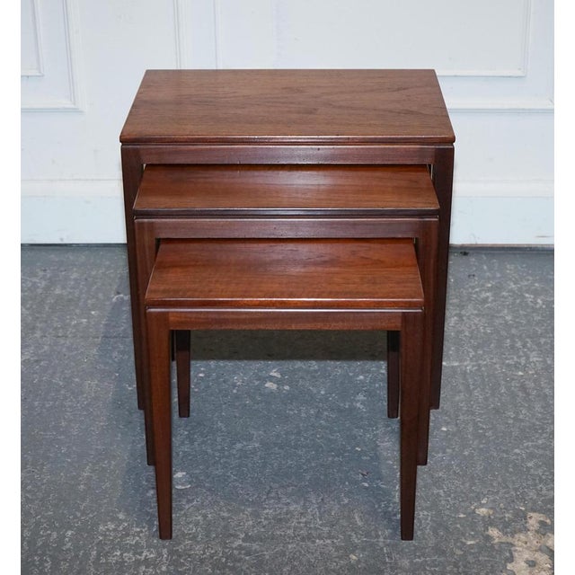 Antiques of London Elegant and functional set of three mid-century Danish nesting tables crafted in richly toned teak....
