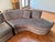 This two piece sectional Serpentine couch reminiscent of Vladmir Kagam style set on casters. The sofa is a muted brownish-...
