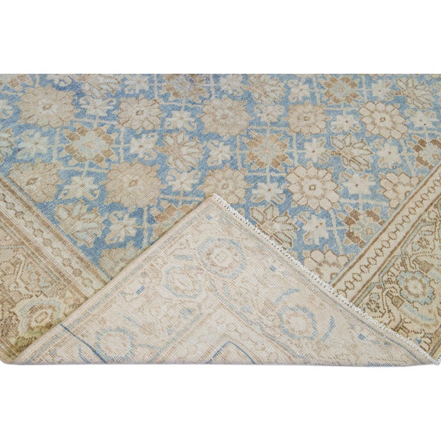 Beautiful antique distressed Tabriz hand-knotted wool rug with a blue field. This Persian rug has a beige designed frame...