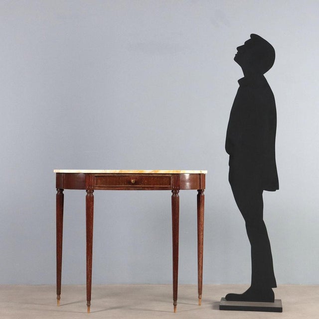 Wall-mounted console table in style made of wood with stained mahogany veneer, turned legs and a marble top. This piece is...