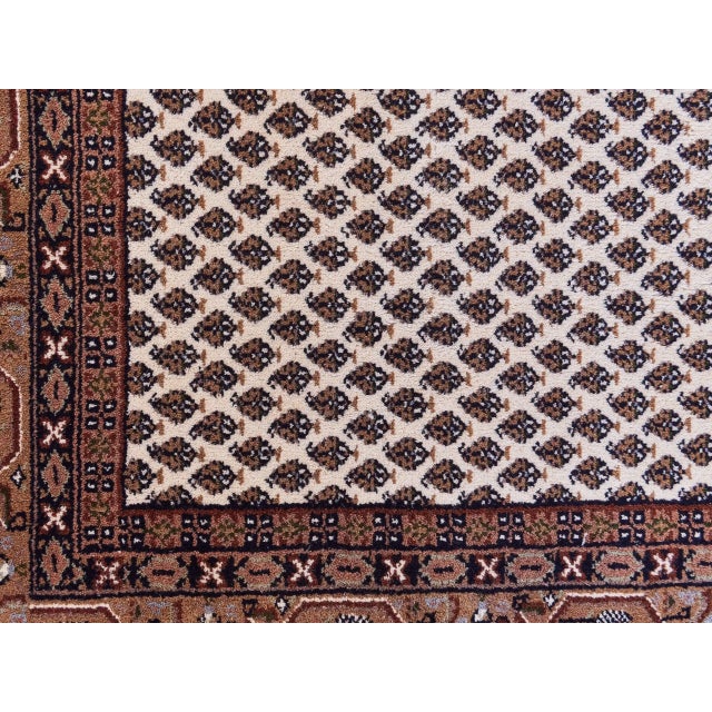 Hand-knotted Persian Saroug rug with a classic endless boot motif. Pleasant earthy colors with predominant cream and...