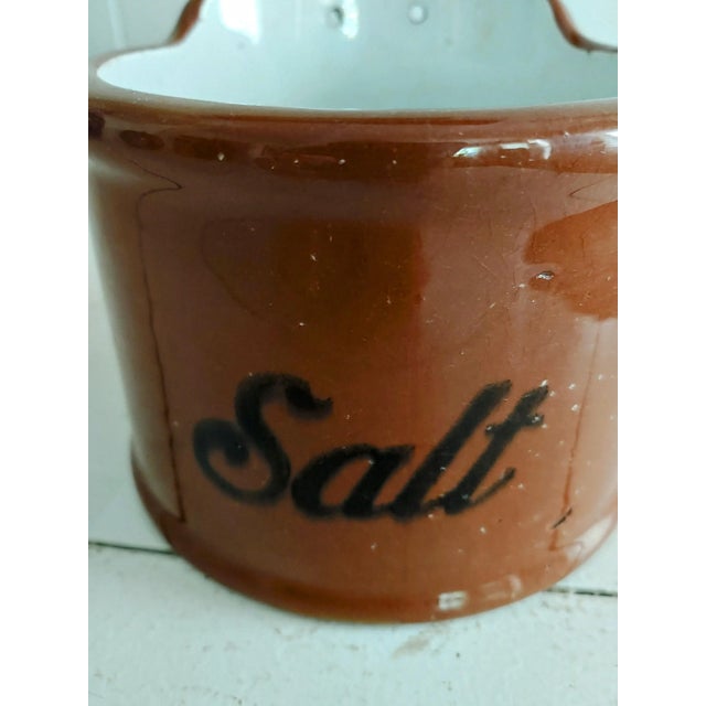 Here's a nice stoneware hanging salt box created by Guernsey of Cambridge, Ohio in the late 1800s. It originally had a...