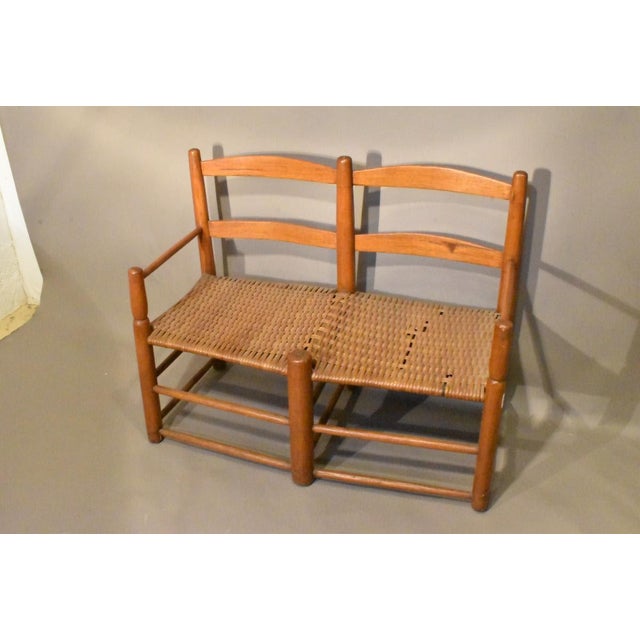 Ladderback form wagon seat with arms, late 18th or early 19th century, American. Woven split reed seat with minor losses....