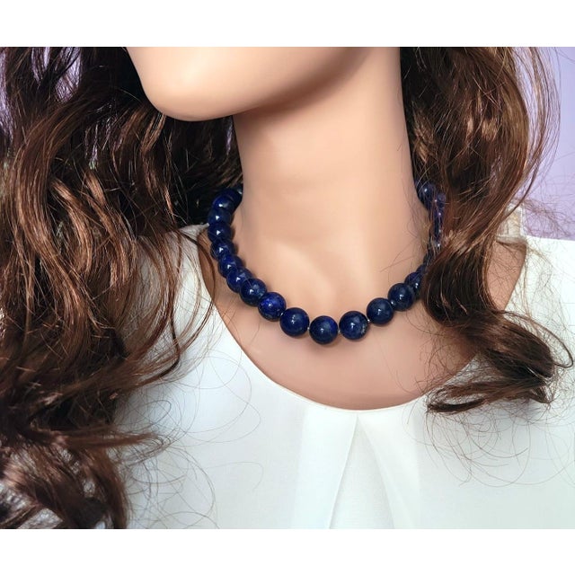 The length of the necklace is 18.5 inches (47 cm). The size of the smooth round beads is 14 mm. The lapis lazuli beads are...