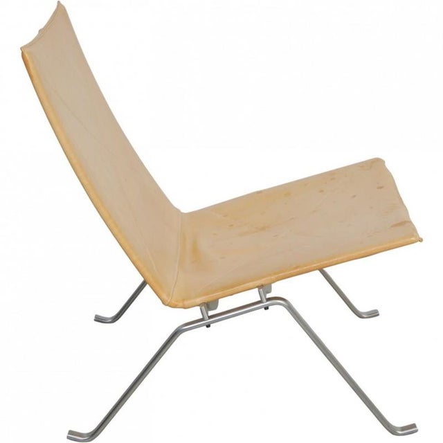 Poul Kjærholm PK22 lounge chair upholstered in original natural leather and with a frame of brushed spring steel. The...