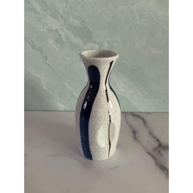 Pretty vintage mid-century Sake set. Carafe and four glasses. In speckled cream-colored ceramic with thick blue stripes...