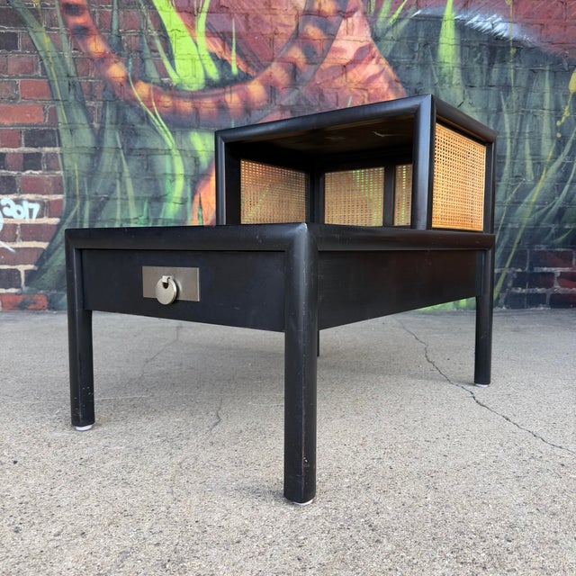 This table exhibits a classic Mid-Century Modern design by Baker Brand. It features a two-tier structure, offering both a...
