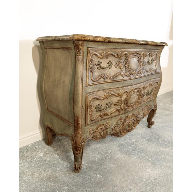 This charming antique Louis XV-style commode exudes timeless French provincial elegance with its classic bombé silhouette,...