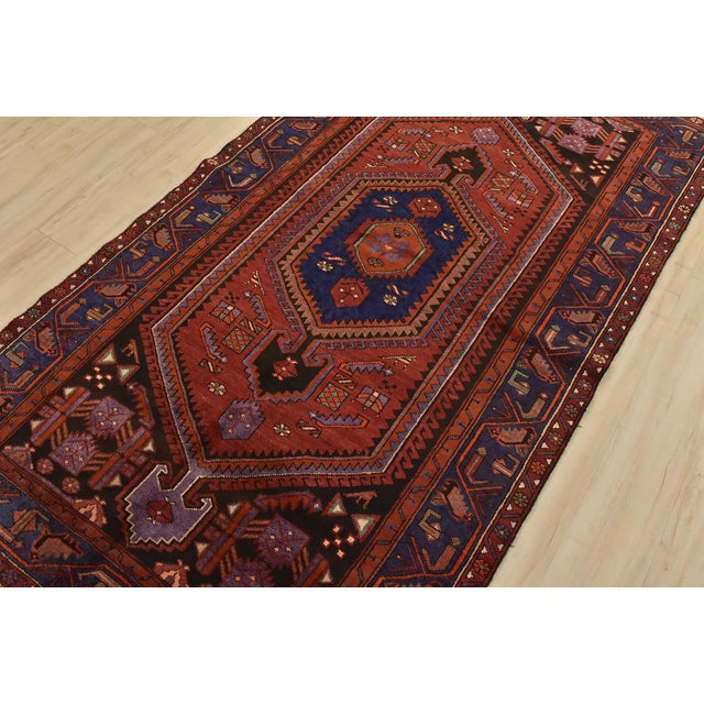 An authentic vintage tribal Hamedan rug hand-knotted with fine wool and natural dyes. This nomadic rug features a central...