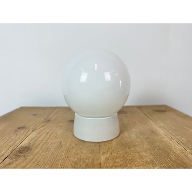 Vintage industrial ceiling or wall light made in former Czechoslivakia during the 1970s. It features a white porcelain...