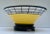 A modern interpretation of an Asian bowl with stand. Clear glass bowl enameled in yellow with a black enamel cage border...