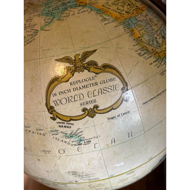 Vintage mid-century hand crafted standing globe with wooden spine and brass base .