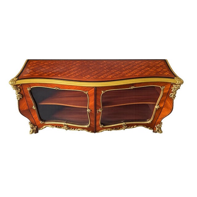 An elegant Napoleon III display cabinet, characterized by a refined curved line and rich French-style decoration. The...