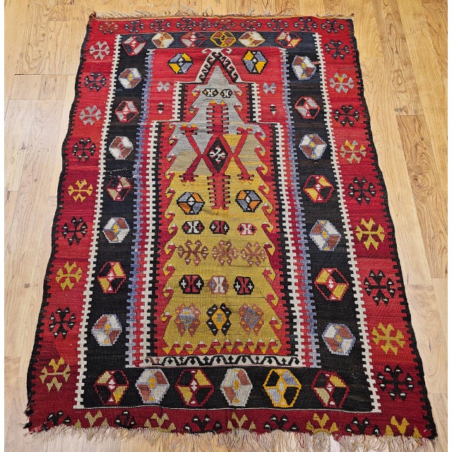 A remarkable survival from the early years of the 20th century, this antique Anatolian kilim features a prayer rug Mihrab...