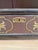 This antique bookcase features a rich, dark-colored finish adorned with intricate gold-colored stencil work along the top...