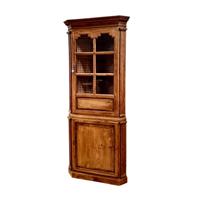 While the corner cabinet was a clever 18th-century response to tight dining spaces, this one made of knotty pine is both a...