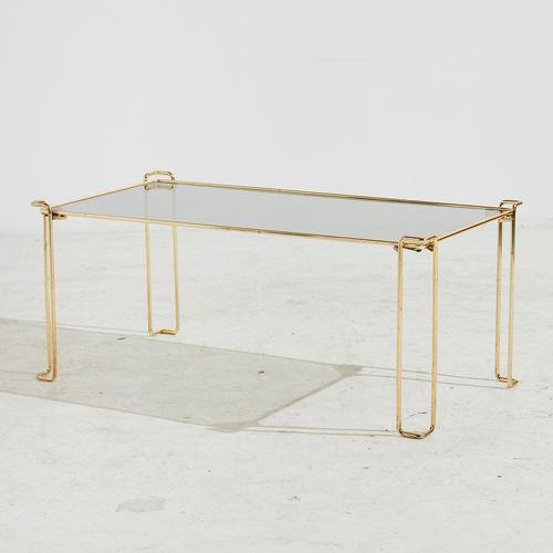 Angular shaped coffee table with metal legs and smoked glass top from the 1980s. with some surface scratches and wear on...
