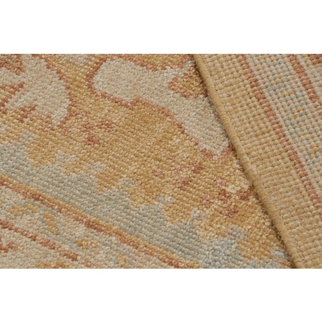 This 12x15 rug from the Modern Classics Collection features a gold field, blue and beige-brown borders underscore...