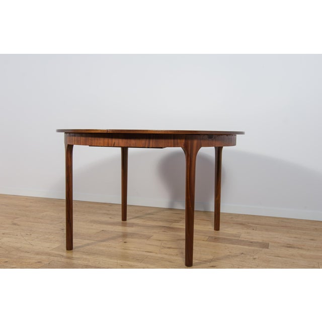 Round extending dining table manufactured by the renowned British furniture maker McIntosh in the 1960s, representing an...