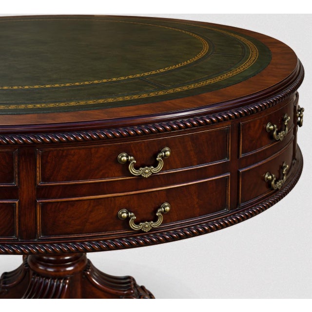 This is a lovely English drum table with Georgian styling. It has a green leather top. The frame is carved mahogany with...