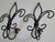 This pair of wrought iron fleur-de-lis candle sconces have a vintage patina with black/bronze finish. They would be great...