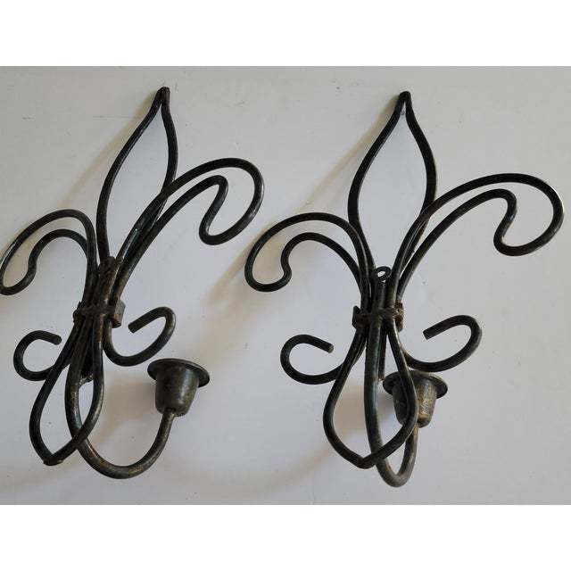 This pair of wrought iron fleur-de-lis candle sconces are a rich vintage, black/bronze finish. They would be great wall...