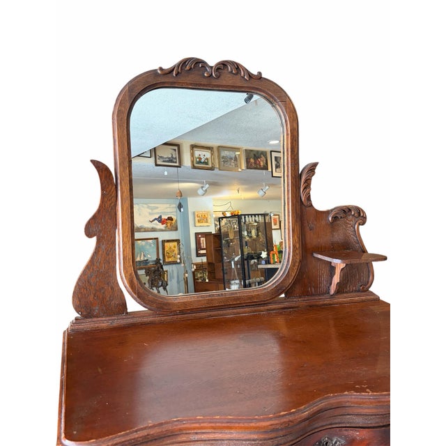A stunning antique tallboy dresser featuring a classic serpentine curved front, five spacious drawers, and an attached...
