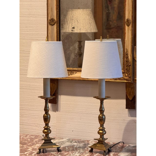 Pair of 18th century brass altar sticks with baluster turned stems on stepped triangular bases and paw feet, now converted...