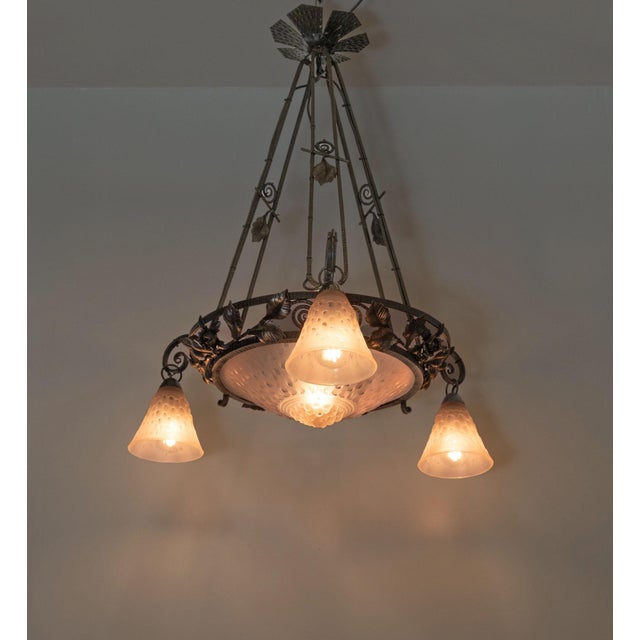 Superb Muller Frères Lunéville signed Art Deco pink frosted and wrought iron chandelier. Circa 1925. The chandelier...