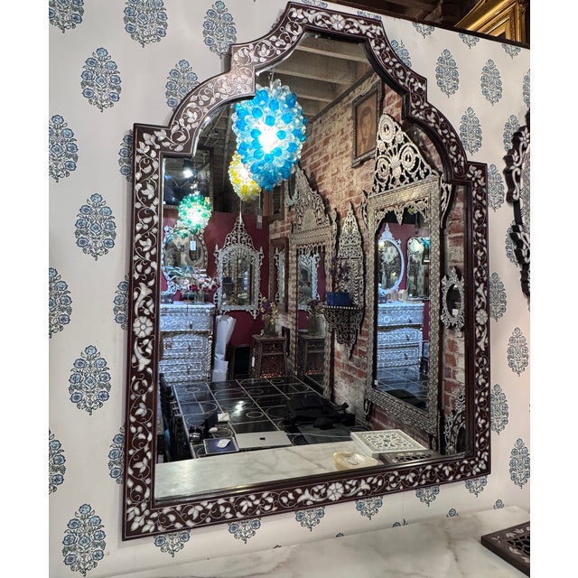 A striking vintage contemporary mirror featuring exquisite handcrafted mother-of-pearl inlay, blending timeless artistry...