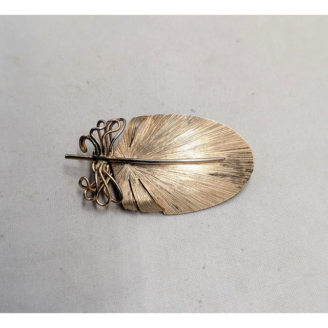 1950s or 1960s goldtone over sterling feather with loops around the base of the feather brooch with security clasp. Marked...