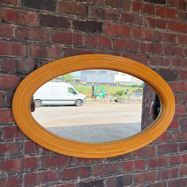A beautiful large oval wall mirror in the style of Gabriella Crespi, featuring a sculptural frame wrapped in tightly...