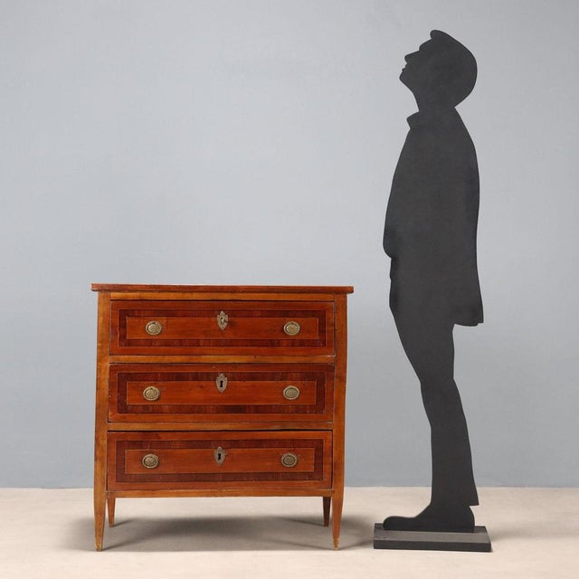Small Neoclassical-style cherry chest of drawers with mahogany, ebony, and maple trim. Three-drawer front, truncated...