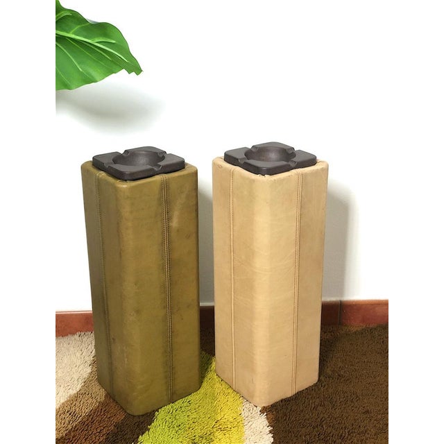 Elegant pair of column ashtrays with a unique design, characterized by a leather covering and cast iron ashtray. Objects...
