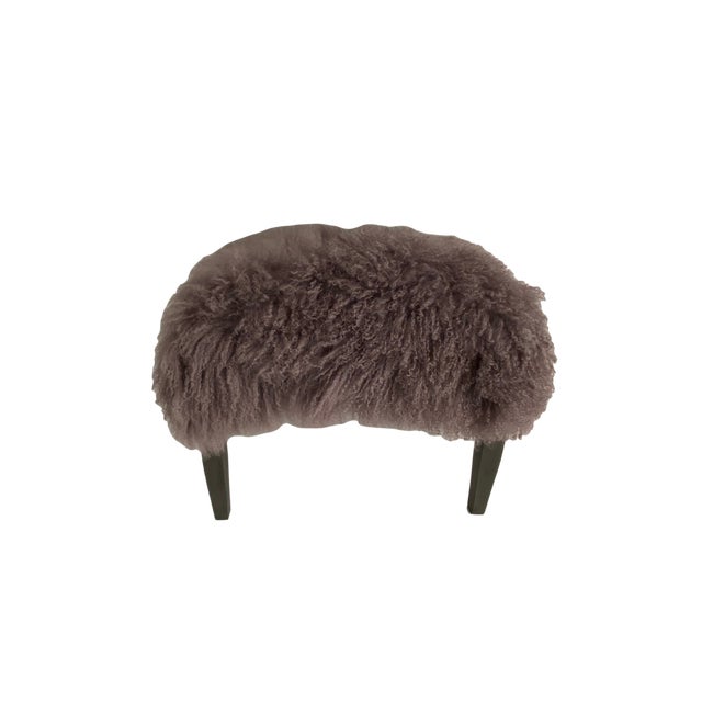 Lush Tibetan lamb upholstered bench/ ottoman in a soft mauve shade of purple with gray painted wood legs.