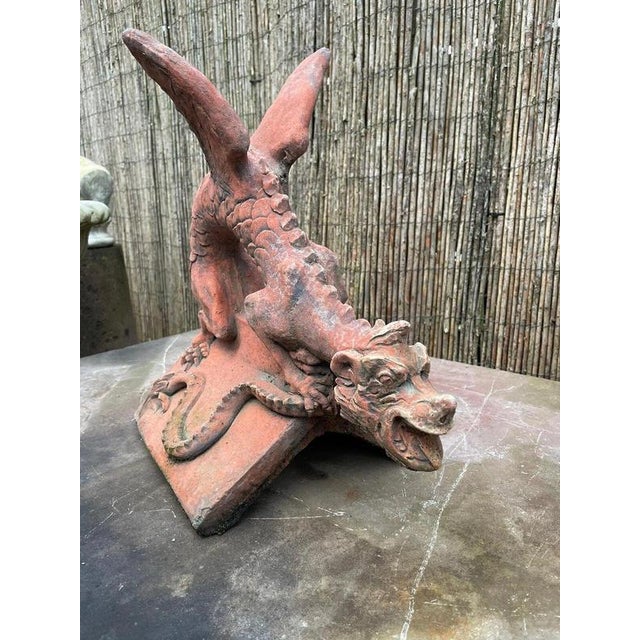 A striking architectural dragon finial, dramatically modelled with an arched, scaled body, raised wings and an expressive...