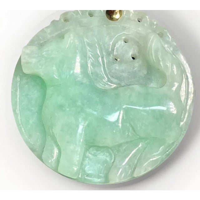 This jadeite jade apple green 30mm. pendant features a carved horse design, representing one of the twelve animals in the...