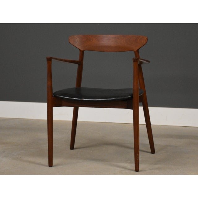 A mid century modern solid teak chair with original black leather by Harry Østergaard for A/S Randers Møbelfabrik. Made in...