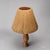 Table lamp made in France around 1960. The turned wood base has a slender, organic silhouette, resting on a discreet...