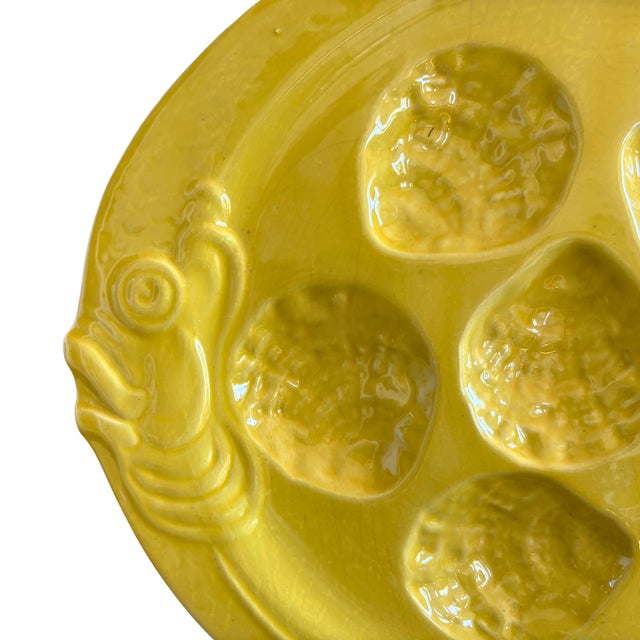 A rare and joyful mid-century French oyster plate in a radiant sunflower yellow glaze, sculpted with six wells and adorned...