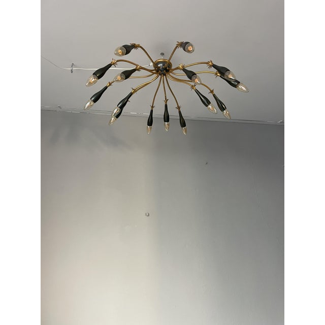 A stunning mid-century modern ceiling lamp with spear-like, elongated bulbs radiating from a central golden base. This...