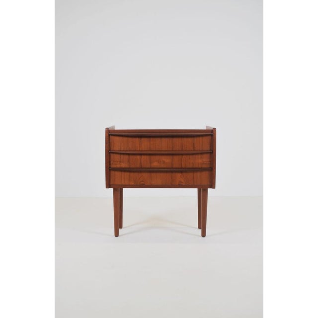 Danish chest of drawers from the 1960s, finished in warm teak veneer. The cabinet features three spacious drawers with...