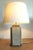 Lamp composed of a travertine mosaic in beige and gray tones, decorated with black ceramic on the sides and enhanced with...