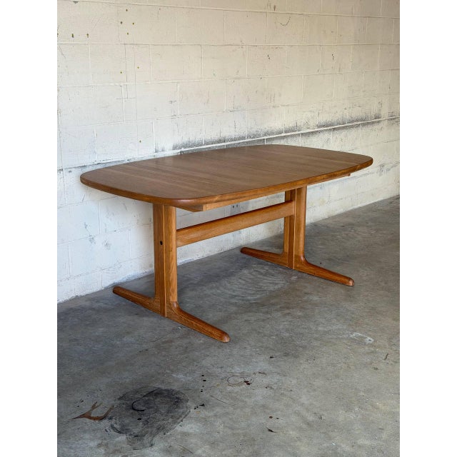 This extendable dining table features a smooth top and a trestle base designed for effortless seating. It delivers classic...